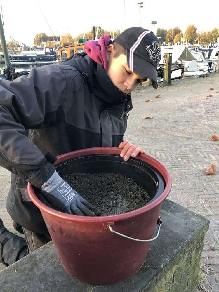 Door de zeef drukken om grove delen te verwijderen.